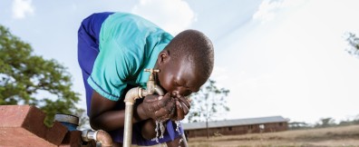 Child in Uganda drinking tap water